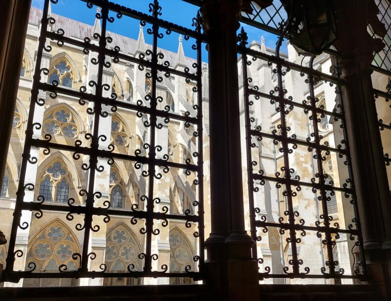 a photo of flying buttresses through a barred window